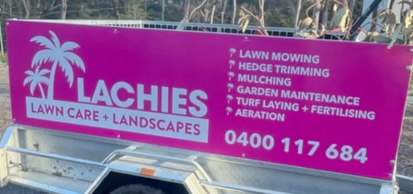 Lachie's hot-pink trailer sign listing his services and phone number